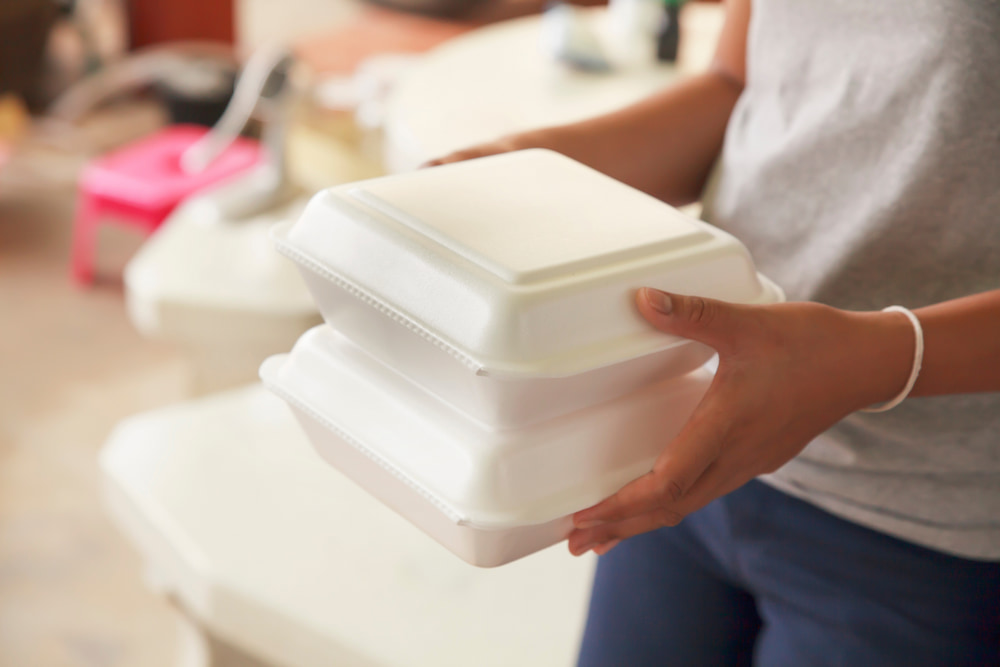 Woman holds Styrofoam food containers